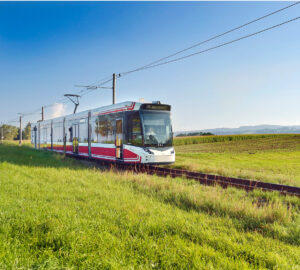 Atterseebahn fährt in der Landschaft durch grüne Wiesen