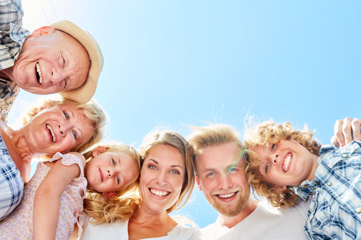 Laughing extended family in the summer with grandparents and two kids
