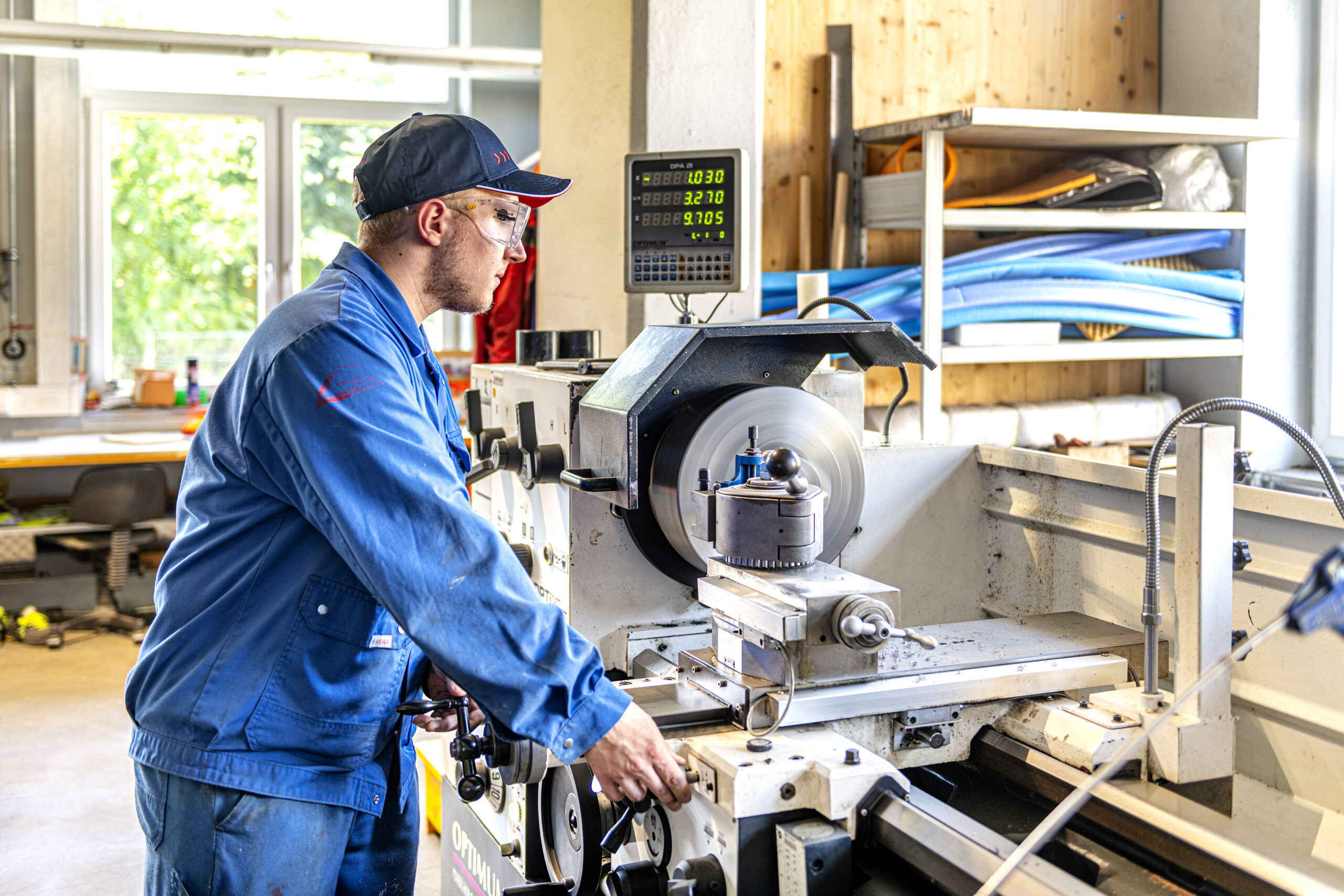 Mitarbeiter steht bei einer Metallbearbeitungsmaschine