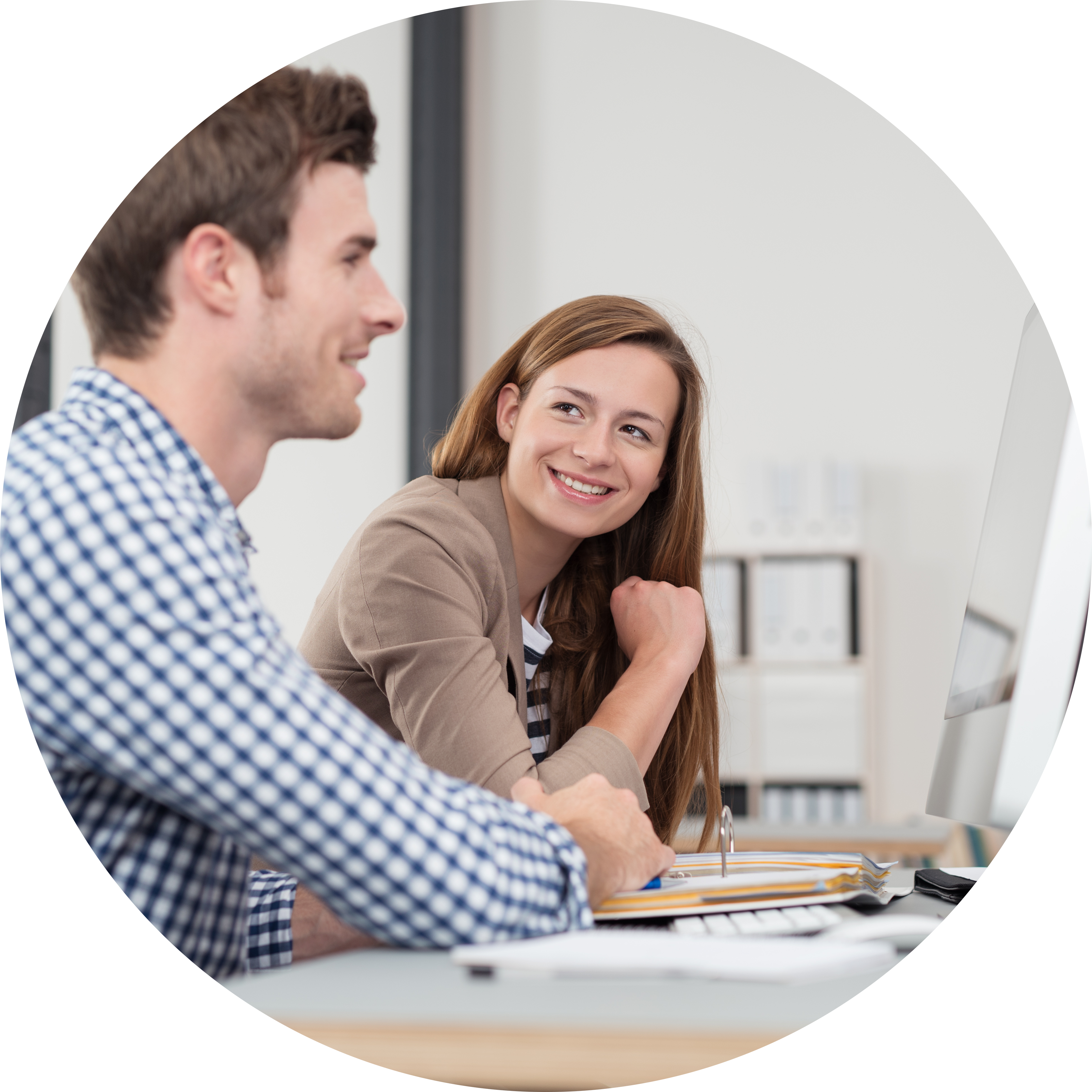 Eine Frau und ein Mann arbeiten an einem Laptop im Büro