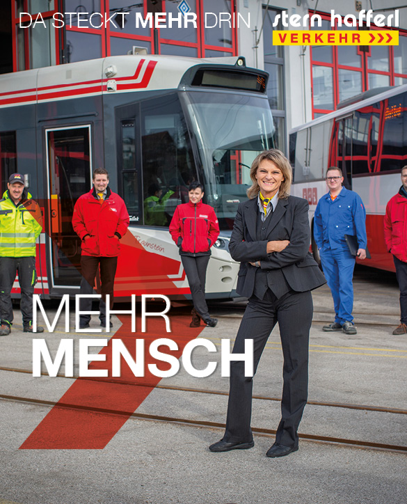 Mitarbeiterin steht vor einer Bahn mit der Aufschrift mehr Mensch