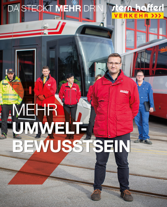 Mitarbeiter steht vor Bahn mit der Aufschrift Mehr Umweltbewusstsein