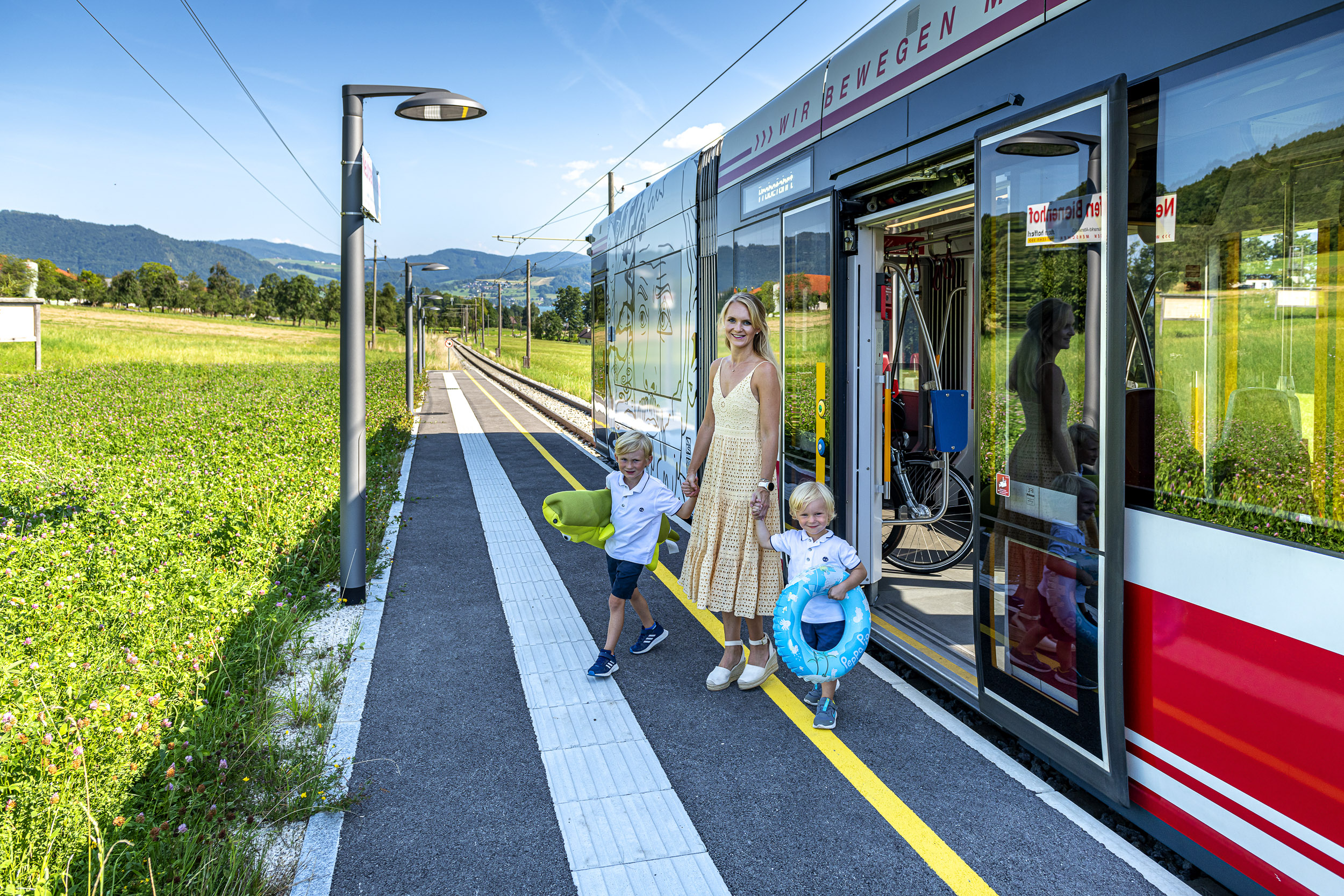 Mutter mit 2 kleinen Kindern steigt aus der Atterseebahn aus