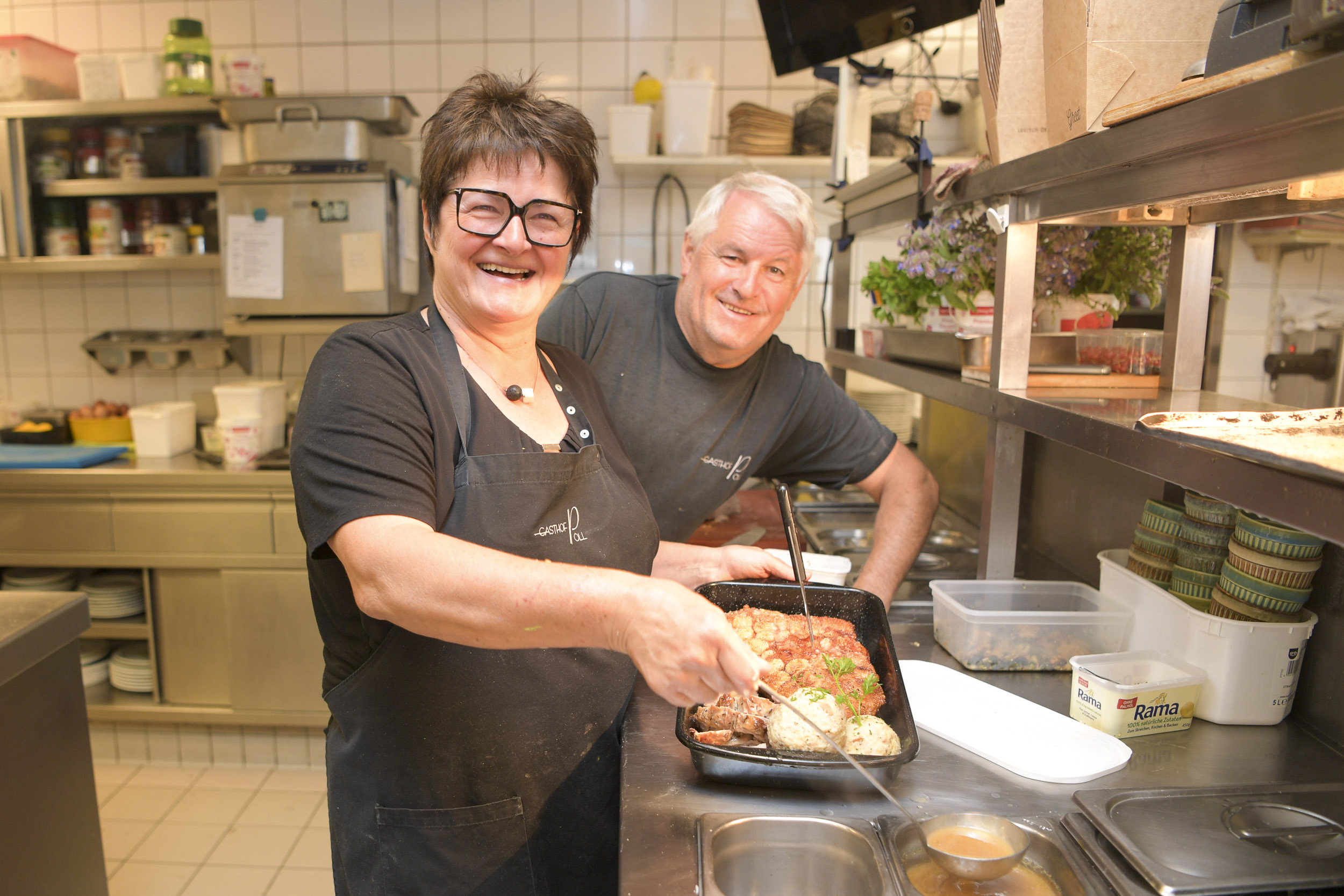 2 Köche in der Küche des Gasthofs Pöll, mit Bratl, lachend