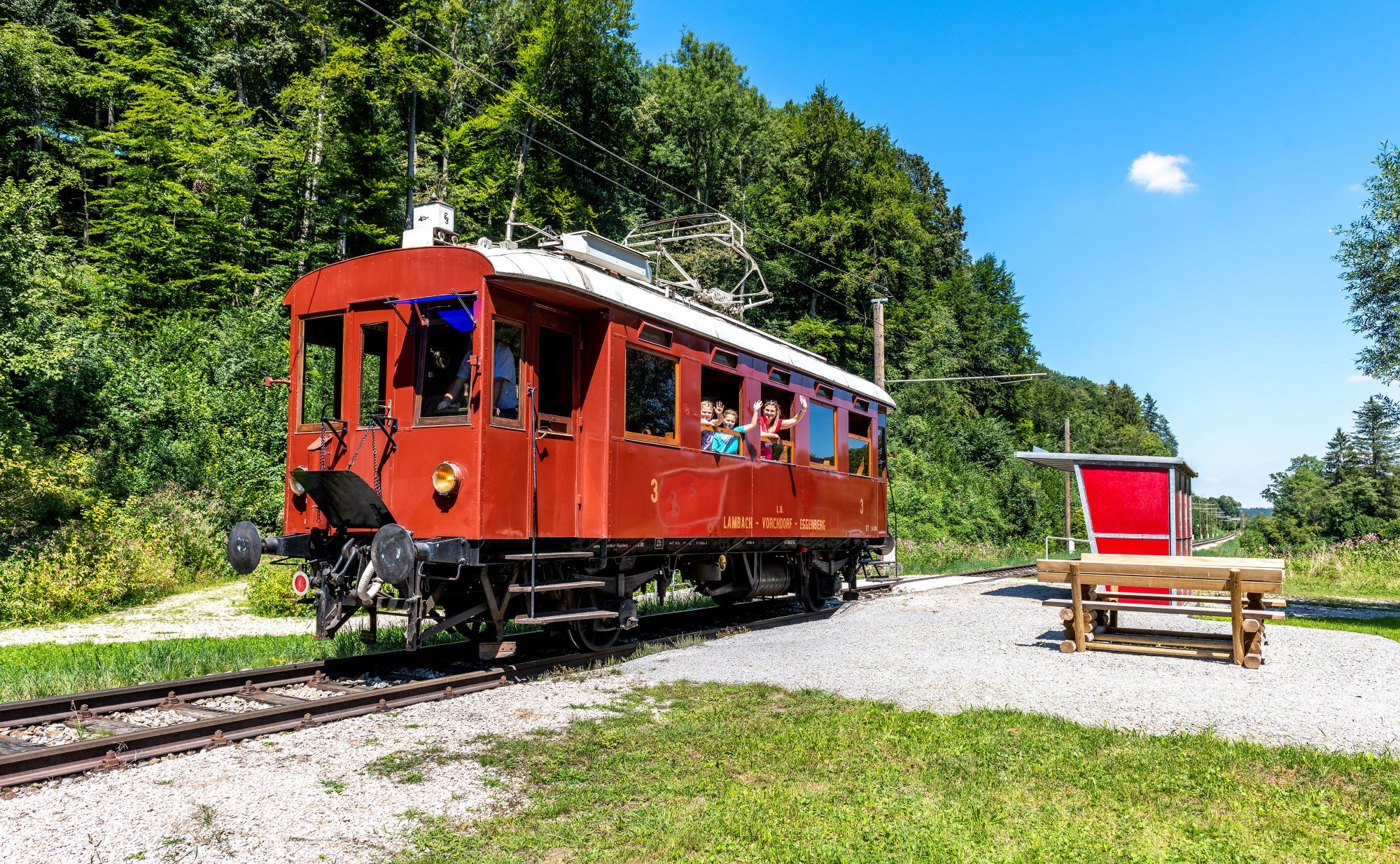 Nostalgiezug der Vorchdorferbahn, zwei Kinder und ihre Mutter winken aus dem Zug