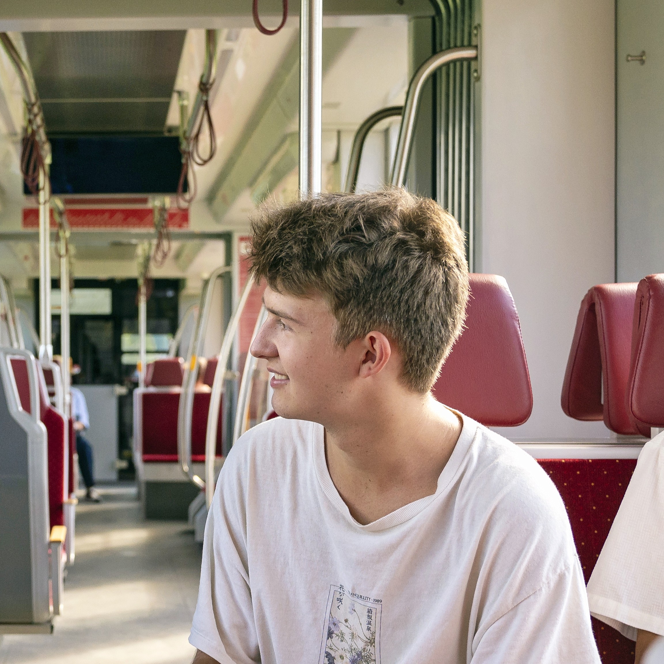 Mann sitzt lachend im Zug