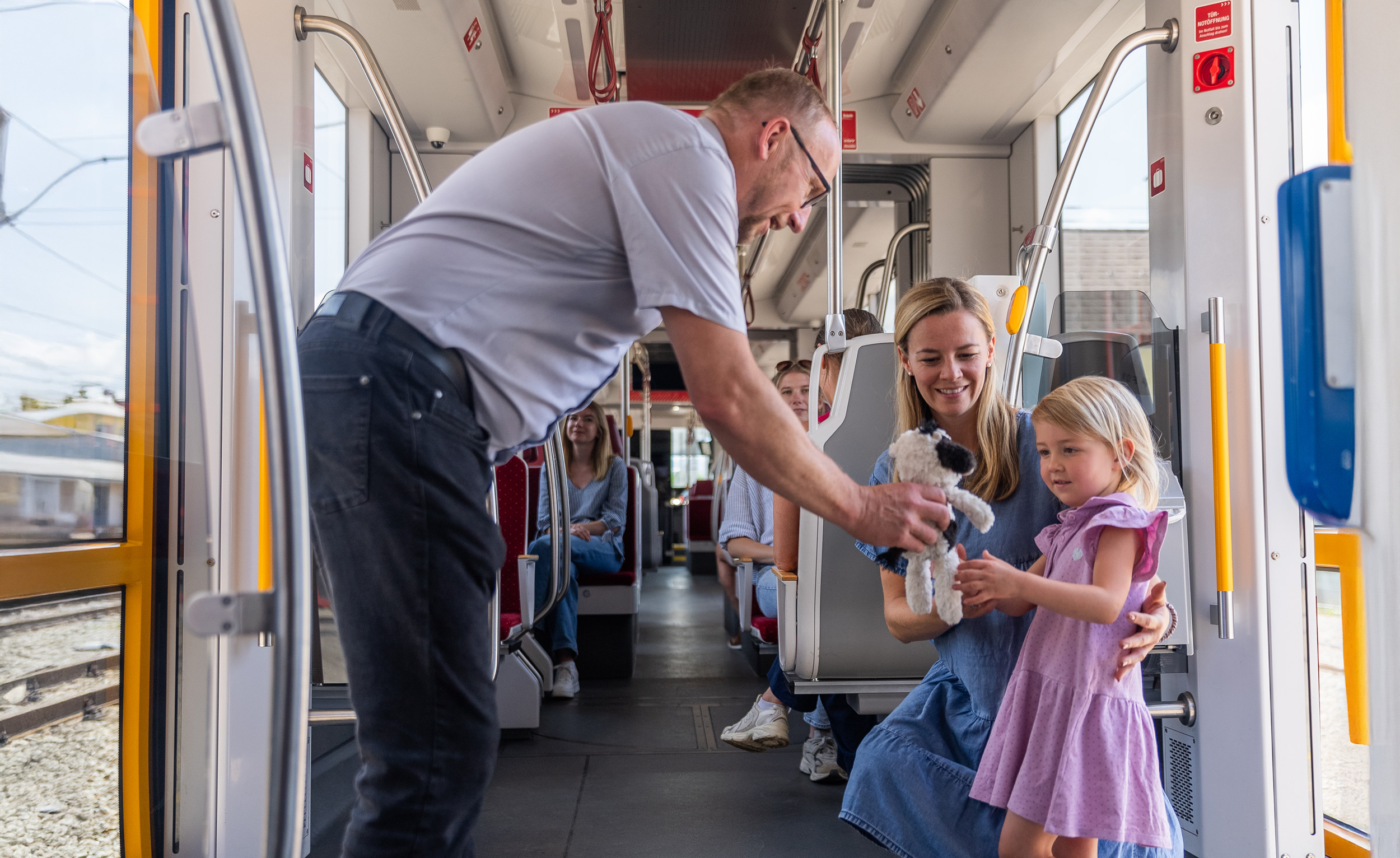 Schaffner gibt einem kleinen Mädchen ihr Stofftier zurück